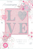 In this image, a beautifully crafted anniversary card rests on a neutral background, its design quietly celebrating enduring romance with the same softness and care you might expect from a bespoke bouquet in Weybridge. The focal point of the card is the word LOVE, elegantly spelled out in raised, velvety glitter, the texture adding depth and a gentle shimmer. The letter O is transformed into a shimmering heart, textured in silver, which catches the light like a tiny piece of jewellery tucked among petals. Surrounding this centrepiece, a ring of delicate florals unfolds in blush, mauve, and pale pink washes, their edges softened as if painted in watercolour. Fine, flowing outlines trace each petal and leaf, giving the impression of lightness, as though the blooms could drift away on a soft breeze along Monument Hill. Subtle flourishes-tiny petals, looping swirls, and discreet butterfly shapes-thread through the design, adding a quiet sense of motion and whimsy reminiscent of an English spring garden just coming into bloom. The text On Our Anniversary appears in an elegant script near the top or side, while the heartfelt line I love you today and always sits in a coordinating style below, both rendered in a refined, unobtrusive font that complements the artwork. The colour palette stays within soft pastel pinks and silvery greys, creating a mood of treasured intimacy and calm. Overall, the card feels like a keepsake-a tender companion to anniversary flowers delivered to a doorstep off Weybridge High Street, marking a shared journey that is soft-spoken yet deeply felt.